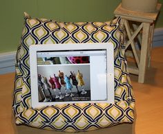 an ipad sitting on top of a chair with a pillow in front of it that is made to look like a photo frame