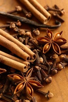 cinnamons, star anise, and cloves on a wooden cutting board