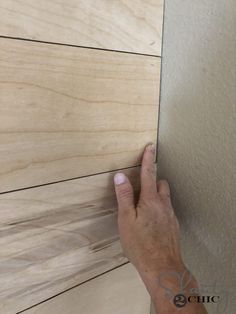 a person's hand is touching the wall with their thumb