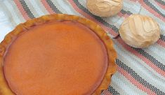 a pie sitting on top of a checkered table cloth next to two other desserts