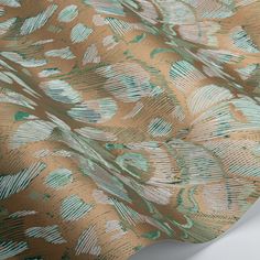 a close up view of a gold and green wallpaper with feathers in the background