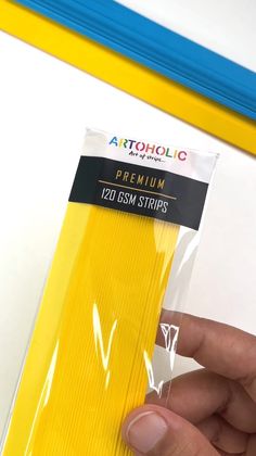 someone is holding up a package of yellow colored paper with the word artholic on it