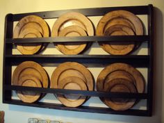 a wall mounted wooden plate rack with plates on it's sides and hanging from the ceiling