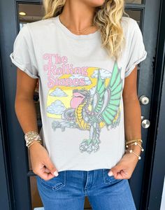 Introducing The Rolling Stones Dragon Tee, a must-have for any music lover. Crafted with a distressed design and short sleeves, this graphic tee boasts a stylish and edgy look. Perfect for concerts or everyday wear, it's a versatile addition to any wardrobe. Show off your love for the iconic band in style. Lilli is wearing a size Small. Height is 5’3, Bust is 32”, Waist 26”, and Hips 33”. Trendy Acid Wash T-shirt For Concert, Trendy Band Logo T-shirt For Concerts, Rock And Roll Cotton T-shirt With Graphic Print, Edgy Short Sleeve T-shirt With Band Logo, Casual Cotton T-shirt For Concert, Spring Distressed Graphic Tee T-shirt, Edgy Acid Wash Short Sleeve T-shirt, Casual Graphic Print T-shirt For Concerts, Trendy Crew Neck Tops For Music Festival