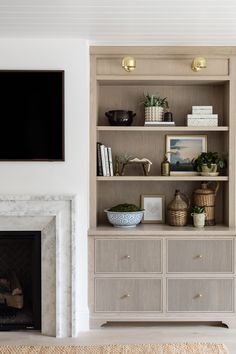 a living room filled with furniture and a fire place next to a wall mounted tv