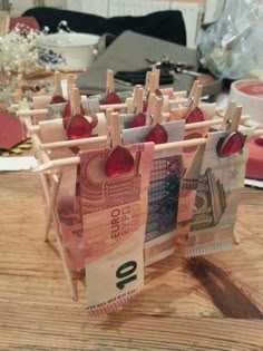 some clothes pins are hanging on the clothes pegs with money notes attached to them