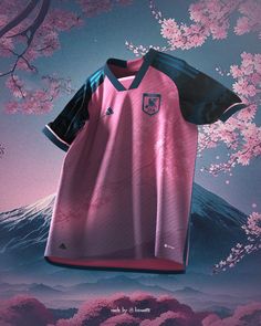 a soccer jersey hanging on a tree with pink flowers in the foreground and a mountain behind it