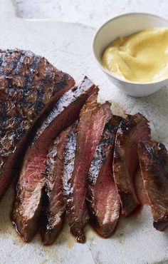 sliced steak with mustard sauce on the side