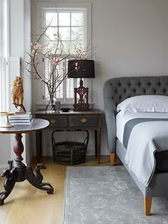 a bed sitting next to a window in a bedroom on top of a hard wood floor