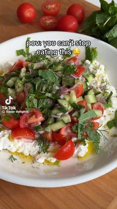 a white plate topped with lots of veggies next to tomatoes and lettuce