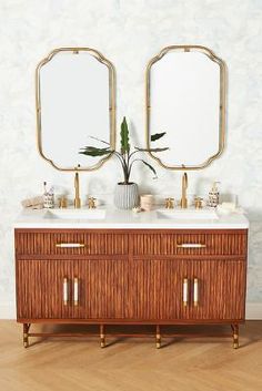 two mirrors are above the double sink vanity in this bathroom with wood flooring and white walls