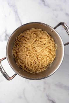 a pot filled with noodles on top of a white counter