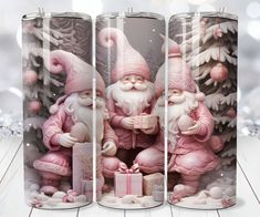 three pink santa clauses with presents in front of snow covered trees and pine cones