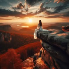 a woman sitting on top of a cliff looking at the sunset