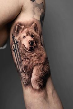 a man's arm with a bear and cross tattoo on it