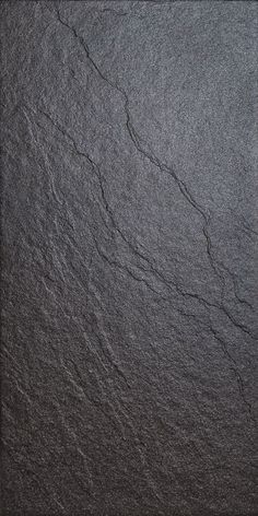 a black slate surface with cracks in the middle and dark gray paint on it's edges