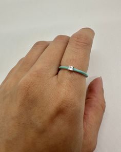 Turquoise enamel stacking ring with a prong set 2.3mm princess cut cubic zirconia center stone. These rings are made of 925 sterling silver with a bright blue turquoise enamel on the outside and silver with a rhodium finish inside. At 1.5mm these rings are great for stacking or wearing on their own. A fun pop of color to your jewelry.  * 925 Sterling Silver * 1.5mm wide  * Princess Cut Cubic Zirconia * Prong set  * Turquoise Enamel  ------------------------------------------ How to care for your Ring Stacking, Enamel Ring, Stacking Ring, Blue Turquoise, Stackable Rings, Stacking Rings, Princess Cut, Bright Blue, Turquoise Blue