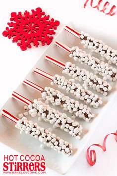 white and red marshmallows are arranged on a plate next to candy canes