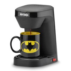 the batman coffee maker is on display with its cup in it's holder and lid