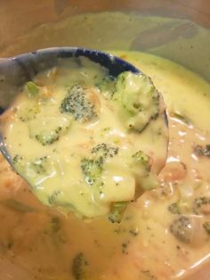 a spoon full of broccoli and cheese soup