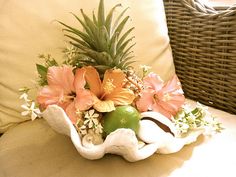 a vase filled with flowers sitting on top of a white couch next to a wicker chair