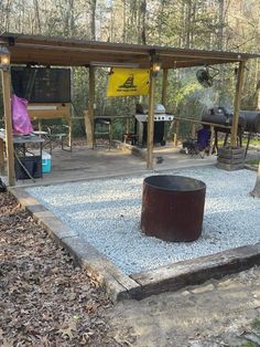 there is a fire pit in the middle of this yard with gravel and rocks around it