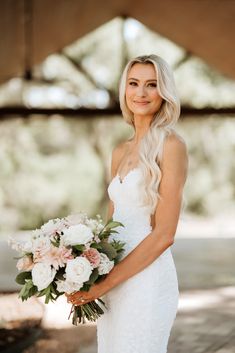 a woman in a wedding dress holding a bouquet