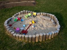 a sand pit with shovels and toys in it