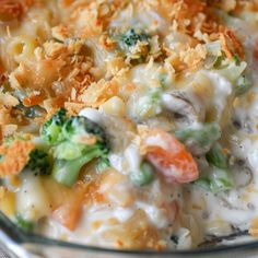 a casserole dish with broccoli, carrots and cheese