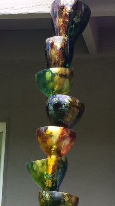 a multi colored glass sculpture hanging from the side of a building