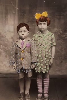 two young children standing next to each other wearing clothes made out of buttons and chains