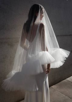 a woman in a white wedding dress and veil