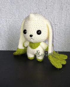 a crocheted stuffed animal sitting on top of a black table next to a white wall