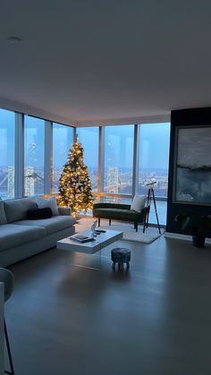 a living room filled with furniture and a christmas tree in the middle of it's windows