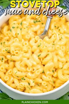 a white bowl filled with macaroni and cheese on top of a blue checkered cloth