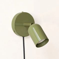 a green wall mounted lamp on a white wall