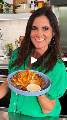 a woman holding a plate with food on it