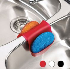 a red and blue brush sitting on top of a sink next to a metal faucet