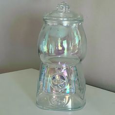 a clear glass jar sitting on top of a white table