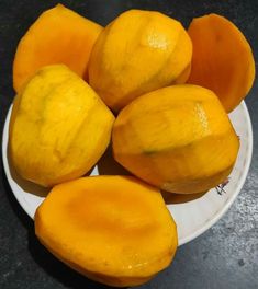 a white plate topped with yellow fruit on top of a table