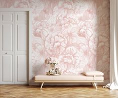 a white bench sitting in front of a pink wallpapered room with flowers on it