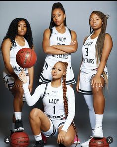 three women in white uniforms holding basketballs