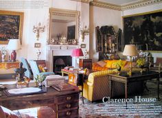 a living room filled with lots of furniture and paintings on the wall next to a fire place