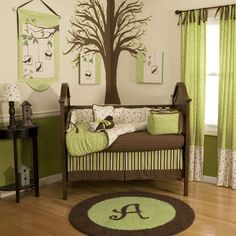 a baby's room with green and brown decor, including a tree on the wall