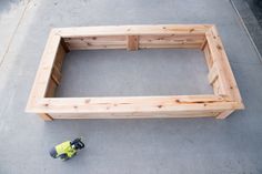 a skateboard laying on the ground next to a wooden frame with one side missing