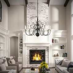 a living room filled with furniture and a fire place under a chandelier hanging from the ceiling