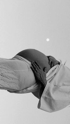 a pregnant woman is flying through the air with her hands on her belly and head