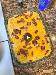 a casserole dish with bacon and cheese in it sitting on a kitchen counter