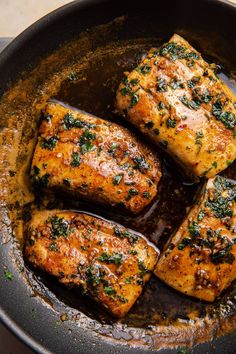 four pieces of meat in a pan with sauce and parsley on the top, ready to be cooked