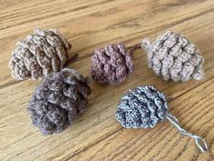 four crocheted balls sitting on top of a wooden table next to a string